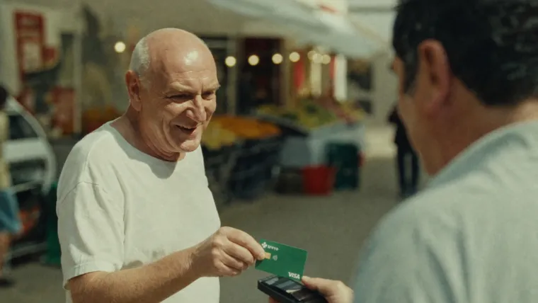 Homem paga com o Trevo Card numa feira de rua na Europa.